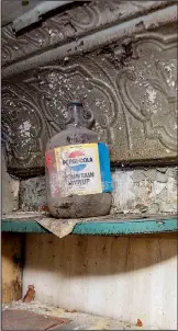  ??  ?? Pressed tin molding in the office of the theater. The shelf holds a jug labeled “Pepsi-Cola Fountain Syrup.”