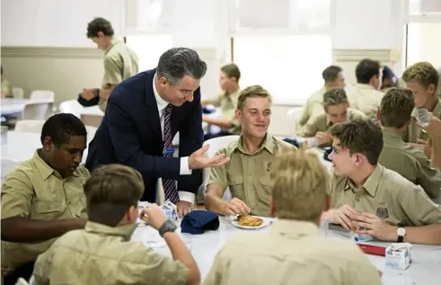  ?? PHOTO: BRODY GROGAN ?? STUDENT CARE: Christian Oneto, dean of boarding at Nudgee College, talks with students.