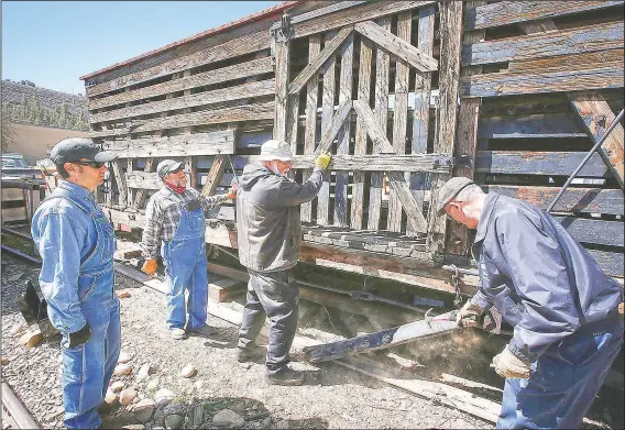  ??  ?? Galloping Goose Historical Society members Chris Pranskatis (from left), Ben Deason, Joe Becker and Bill Wolf remove a door from a stock car built in 1903 to transport livestock, as they ready the vehicle for display in Dolores, Colo. The historical society is in the process of stabilizin­g the car and four other types of narrow-gauge railcars to put on display in Dolores.
(The Durango Herald/Jerry McBrid)