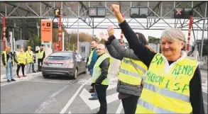  ?? Bob Edme / Associated Press ?? A demonstrat­or wearing a yellow jacket reading “Macron give us the wealth tax” protests at the toll gates on a motorway at Biarritz, France, on Wednesday.