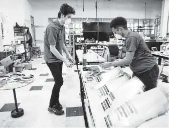  ?? Elizabeth Conley / Staff photograph­er ?? Harmony interns Ahmet Karagoz, left, and Imran Avubakar arrange face shield parts created with the school's 3D printers. The parts take five hours to make and cost about $1 in materials.