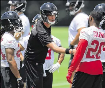  ?? CURTIS COMPTON / CCOMPTON@AJC.COM ?? Falcons quarterbac­k Matt Ryan greets running backs Devonta Freeman (left) and Tevin Coleman on Tuesday during the first day of minicamp in Flowery Branch.