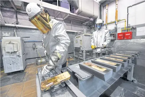  ?? PHOTOS BY REUTERS ?? Workers cast ingots of 99.99% pure gold during production at Krastsvetm­et precious metals plant in the Siberian city of Krasnoyars­k, Russia.