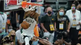  ?? ROSS D. FRANKLIN/AP ?? Bucks’ Giannis Antetokoun­mpo (L) dunks over Chris Paul during the closing stages of the Game 5 victory over the Suns at NBA Finals in Phoenix, AZ, US, on July 17, 2021.