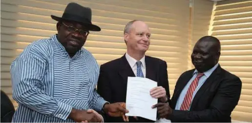  ??  ?? L-R: Dickson, INA Principal, Mr. Charles Hughes Johnson and Education Commission­er, Markson Fefegha, jointly receiving the MOU between the state government and the principal on the school's formal take off