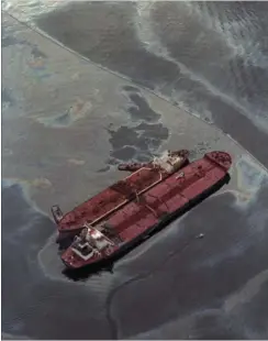  ?? FOTO: AP ?? Tankeren Exxon Baton Rouge ( tv.) pumper råolie fra det havarerede Exxon Valdez. Trods roligt vejr lykkedes det ikke at inddæmme den lækkede råolie med flydespærr­inger.