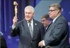  ?? — AFP ?? US Secretary of State Rex Tillerson holds the Arctic Council chair’s gavel before handing it to Finnish Foreign Minister Timo Soini as Finland becomes the chair during the plenary session of the Arctic Council meeting in Fairbanks.