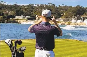  ?? DOUG FERGUSON AP ?? Justin Thomas stops to take a photo of the 18th hole at Pebble Beach on Monday during the AT&T Pebble Beach Pro-Am. Good weather was expected to give way to rain.