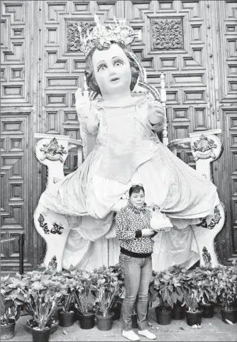  ??  ?? Una mujer posa ante un Niño Dios gigante en la Catedral Metropolit­ana