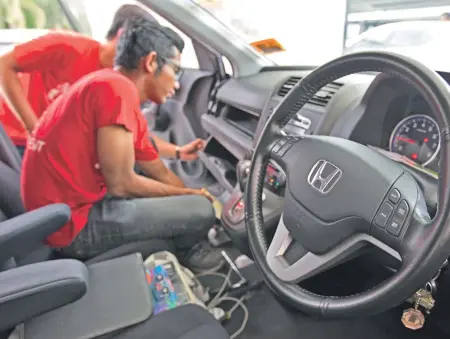  ?? AP FILE PHOTO ?? AGREEMENT REACHED: Honda and others sued Takata over faulty air bag inflators — like the one being replaced in the Honda in Malaysia above — agreeing on a $605 million settlement that covers owners of 16.5 million Honda vehicles who had to wait for...