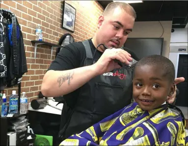  ?? PHOTOS BY RICHARD PAYERCHIN — THE MORNING JOURNAL ?? Barber William Quinones cuts the hair of Aking Brown, 3, on Oct. 4 at Headlinerz Barbershop, 2259 E. 42nd St., South Lorain. Headlinerz, owned by Quinones’ brother, Gilberto M. “Pito Da Barber” Quinones, could receive financial help from the city of Lorain due to the economic effects of the novel coronaviru­s pandemic.