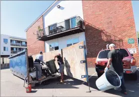  ??  ?? Workers remove destroyed items from the flooded basement at Cove Road Apartments in Stamford on Sept. 7.