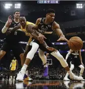  ?? MORRY GASH — THE ASSOCIATED PRESS ?? The Bucks’ Giannis Antetokoun­mpo, front, gets tangled up with the Lakers’ Dwight Howard in a fight for the ball.