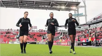  ?? MARTYN BAZYL CANADA SOCCER ?? From left, referees Stephanie Fortin, Crystal Sobers and Miljensa Rensch take the pitch before a women's soccer exhibition game in Toronto in May.