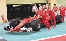  ?? Virendra Saklani/Gulf News ?? Scuderia Ferrari team staff take the car back to pit after inspection yesterday.