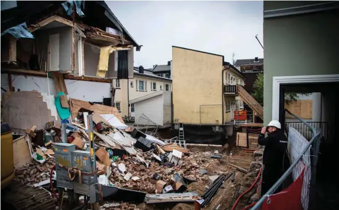  ?? FOTO: TORMOD FLEM VEGGE ?? En kvinne ble skadet da en vegg i dette huset kollapset. Her er en krimteknik­er på stedet fredag. Han sikrer seg bildebevis.