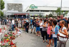  ?? — EPA ?? tragic loss: People laying flowers in front of the Olympia mall in Munich.