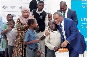  ?? (Courtesy pic) ?? DPM Themba Masuku presenting the pupils who attended the launch with dignity packs and shoes worth about E206 000.