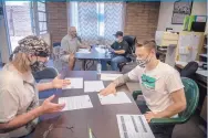  ??  ?? Barry Ore, right, works with Rory Wolf, a peer support specialist, going over questionai­res to be used during interviews with recently released inmates. Best Chance serves people recently released from prison through peer support groups and other resources.