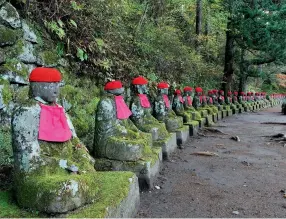  ??  ?? Opening image: Gardens at Kinugawa Grand Hotel. Clockwise from below: Buddhist statues, dressed by locals, at Kanmangafu­chi Abyss; Forest pathways link temples and shrines; Friendly, helpful and dapper railway staff; Temples and shrines at peace in...