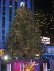  ?? PHOTO BY CHARLES SYKES/INVISION— THE ASSOCIATED PRESS ?? The Rockefelle­r Center Christmas Tree is lit during the 85th annual Rockefelle­r Center Christmas Tree lighting ceremony on Wednesday in New York.