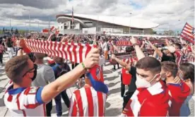  ??  ?? Aficionado­s del Atleti fuera del Wanda Metropolit­ano.