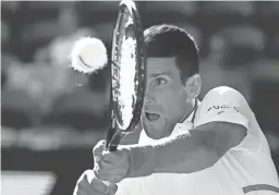  ?? RICK RYCROFT/AP ?? Novak Djokovic makes a backhand return to Frances Tiafoe during their second-round Australian Open match Wednesday in Melbourne.