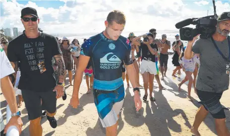  ??  ?? Mick Fanning walks from Snapper Rocks for the last time as a profession­al surfer after being knocked out of the Quiksilver Pro, watched by his mum Liz Osborne (inset), who was quick to console her son afterwards (below). Main picture: NIGEL HALLETT