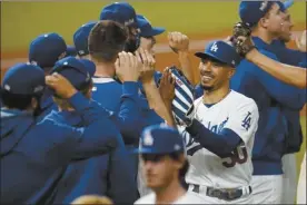  ?? AP photo ?? The Dodgers’ Mookie Betts celebrates with teammates after Los Angeles defeated the San Diego Padres 5-1 in the opener of their NL Division Series on Tuesday.