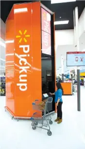  ?? CONTRIBUTE­D PHOTO ?? A shopper gets her order at a Walmart pickup tower. The towers are designed to fulfill a customer’s online order faster, according to the retailer.