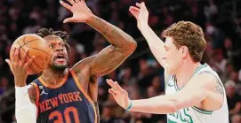  ?? Sarah Stier/TNS ?? Julius Randle (30) of the New York Knicks goes to the basket as Mike Muscala (57) of the Boston Celtics defends during the second half on Feb. 27.