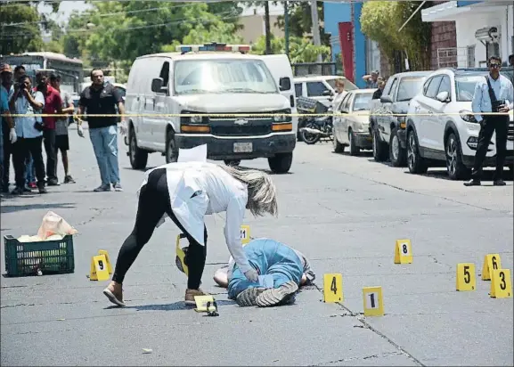  ?? JUAN CARLOS CRUZ / EFE ?? Asesinato. Policía científica junto al cuerpo del periodista Javier Valdez, muerto a tiros en la ciudad de Culiacán