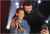  ??  ?? Moroccan Hamza Labyad (left), the winner of season two of the “The Voice Kids: Ahla Sawt”, poses for a picture with his trophy and a member of staff.