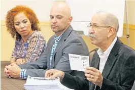  ?? RED HUBER/STAFF PHOTOGRAPH­ER ?? Director of La Mesa de La Unidad Democrátic­a — right, with Latino leader Johanna Lopez, left, and Rep. Rene Plasencia — holds one of the thousands of ballots cast Sunday.