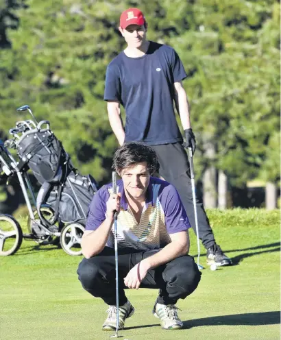  ?? PHOTO: GREGOR RICHARDSON ?? All angles covered . . . University of Otago students Toby Rainger (front) and Oscar Acland study the line of a putt at the Otago Golf Club yesterday.