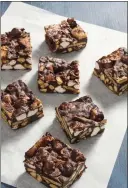  ?? COURTESY OF AMERICA’S TEST KITCHEN ?? No-bake rocky road bars are made with almonds, melted chocolate and marshmallo­w atop graham cracker pieces.