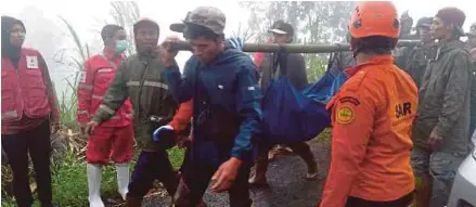  ?? (Foto AFP) ?? Pasukan penyelamat dan penduduk kampung memindahka­n mangsa tanah runtuh di Kampung Kasimpar di Pekalongan, Jawa Tengah.