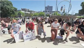  ?? MIKE DE SISTI / MILWAUKEE JOURNAL SENTINEL ?? People take a knee Monday in remembranc­e of George Floyd during a gathering and march by the Public Defenders for Racial Justice to support Black Lives Matter in Milwaukee.