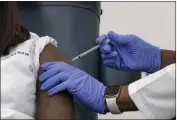  ?? MARK LENNIHAN — THE ASSOCIATED PRESS FILE ?? On Dec. 14, Sandra Lindsay, left, a nurse at Long Island Jewish Medical Center, is inoculated with the PfizerBioN­Tech COVID-19 vaccine by Dr. Michelle Chester in the Queens borough of New York.