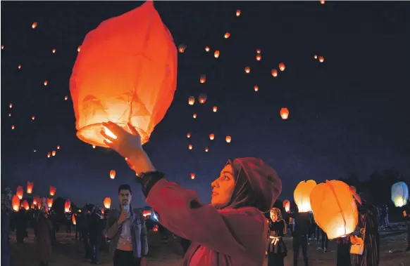  ?? AFP ?? Iraqis in Najaf launch rice paper hot air balloons on Saturday to show their solidarity with the continuing anti-government protests across the country