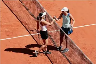  ?? Ryan Pierse / Getty Images ?? Iga Swiatek, right, of Poland, shakes hands with American Jessica Pegula after Swiatek’s straight-sets win at Roland Garros Stadium in the French Open.