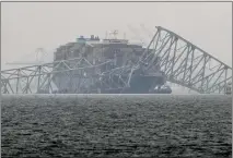  ?? MATT ROURKE — THE ASSOCIATED PRESS ?? The container ship Dali rests against the wreckage of the Francis Scott Key Bridge on Thursday in Baltimore. After days of searching through murky water for the workers missing after the bridge collapsed, officials are turning their attention Thursday to a massive salvage operation. Four missing workers are likely within a `superstruc­ture' of debris.