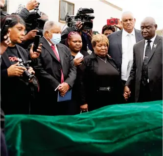  ?? ?? FILE - Civil rights attorney Ben Crump, center right, Bettersten Wade, center, mother of Dexter Wade, a 37-year-old man who died after being hit by a Jackson, Miss., police SUV driven by an off-duty officer, watches her son’s body transferre­d to a mortuary transport after being exhumed from a pauper’s cemetery near the Hinds County Penal Farm in Raymond, Monday, Nov. 13, 2023. After men in near Mississipp­i’s capital were buried in a pauper’s cemetery without their relatives’ knowledge, the U.S. Justice Department said Thursday that it will help the city’s police revamp their policies for performing next-of-kin death notificati­ons. (Photo by Rogelio V. Solis, AP File)