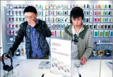  ?? XU KANGPING / FOR CHINA DAILY ?? Customers try Xiaomi smartphone­s at an outlet of Xiaomi Corp in Hangzhou, capital of Zhejiang province.