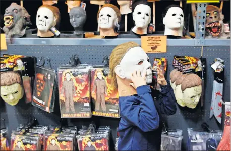  ?? [NATE BILLINGS/ THE OKLAHOMAN] ?? Dristan Holland, 8, tries on a Michael Myers mask at Halloween Warehouse OKC on Tuesday.