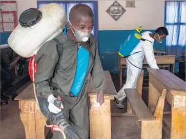  ?? Rijasolo AFP/Getty Images ?? HEALTH MINISTRY workers spray pesticide to kill plague-carrying f leas at a primary school in Antananari­vo, Madagascar’s capital. More than 380 cases of plague have been reported in the country this year.