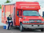  ?? EDDIE MOORE/JOURNAL ?? Santa Fe County Assistant Fire Chief Martin Vigil, director of county’s Office of Emergency Management, climbs aboard the emergency management vehicle at a vaccine clinic at SF Fairground­s in May.