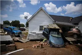  ?? Photograph: Brett Carlsen/Getty Images ?? Vehicles are piled up next to a house destroyed by flooding on Monday in Waverly, Tennessee.