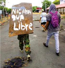  ?? FOTO ?? Una joven camina en medio de las protestas, que han durado cinco días, en Managua Nicaragua.