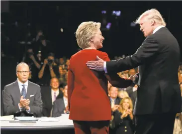  ?? JOE RAEDLE/ASSOCIATED PRESS ?? Hillary Clinton and Donald Trump shake hands after the debate as moderator Lester Holt looks on.